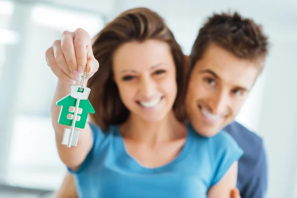 A stock photo is shown, with a couple holding up the keys to their newly purchased home. The photo could be considered generative AI under normal circumstances.